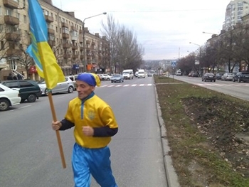 В Запорожье по центральному проспекту бегал активист с флагом в желто-синей одежде фото