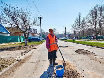 В Запорожской области старушка с лопатой ”латает” ямы на дорогах фото