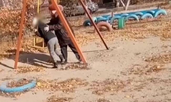 Толкала и била по голове:  в Запорожье бабушка пыталась заставить внука кататься на качели фото