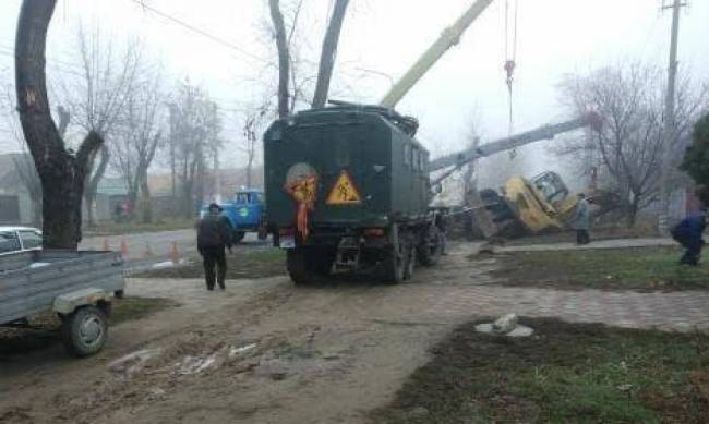 В Мелитополе произошло коммунальное ДТП - под землю ушел экскаватор (фото, видео) фото